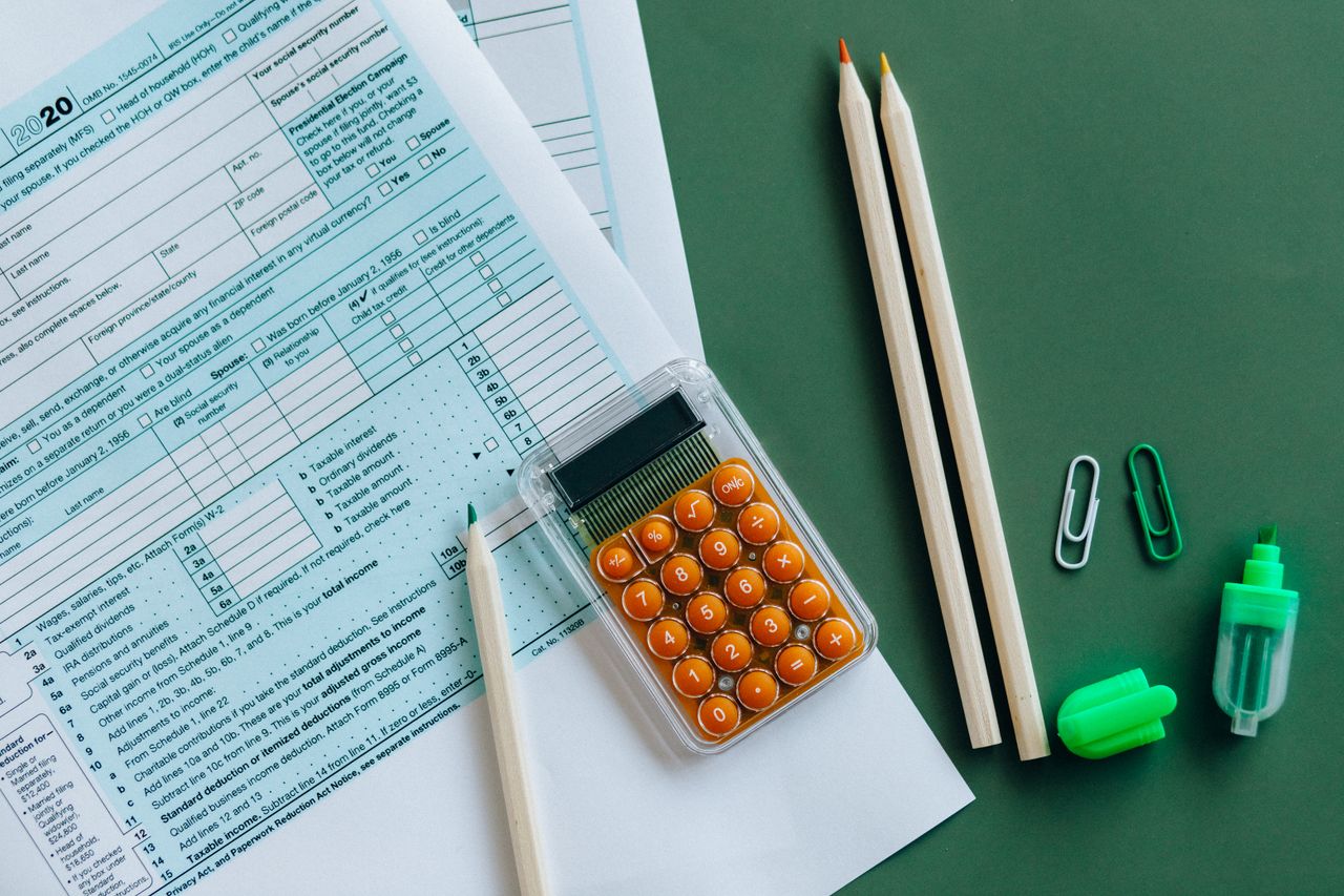 Mastering the First Impression: Your intriguing post title goes here Flat lay of tax forms, calculator, pencils, and clips on green surface, ideal for finance or accounting themes.
