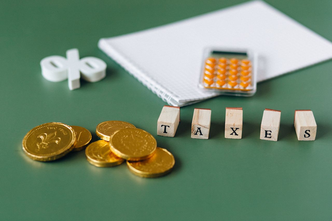 The Art of Drawing Readers In: Your attractive post title goes here Close-up of tax-related items including coins, calculator, and word 'taxes' on a green background.